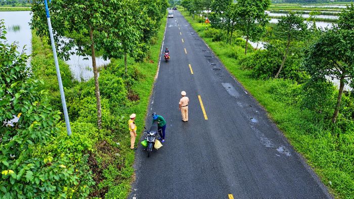 CSGT phân luồng, cảnh báo người dân tại những điểm nóng về ổ gà. Ảnh: Ký Long