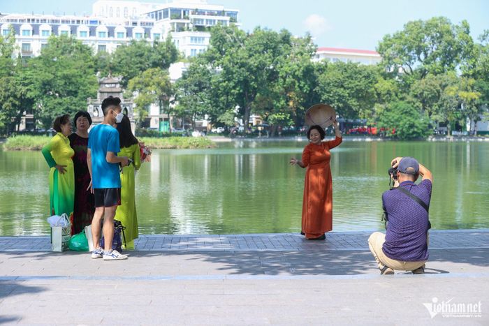 Trong cái nắng cuối mua thu, hồ Gươm là nơi được các mẹ, các chị chọn để chụp ảnh lưu  trong các tà áo dài truyền thống.