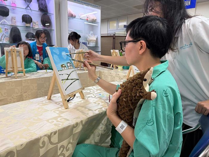 Dù vẽ tranh hay làm bất cứ hoạt động gì, chị T. luôn ôm chặt chú tê tê nhồi bông. Mọi người tại Khoa Tuyến vú - Bệnh viện Chợ Rẫy cho biết, từ lúc nhập viện chưa từng thấy chị tách rời món đồ này. Ảnh: Thanh Huyền