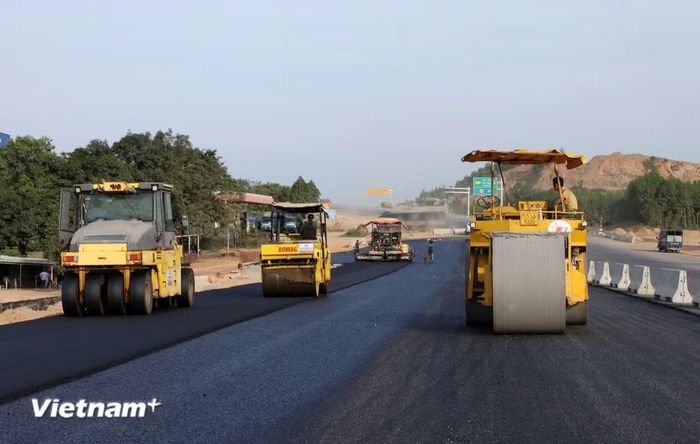 Nhà thầu huy động máy móc, nhân lực để thảm những mét bê tông nhựa dự án đường bộ cao tốc. (Ảnh: Khánh Hùng/Vietnam+)