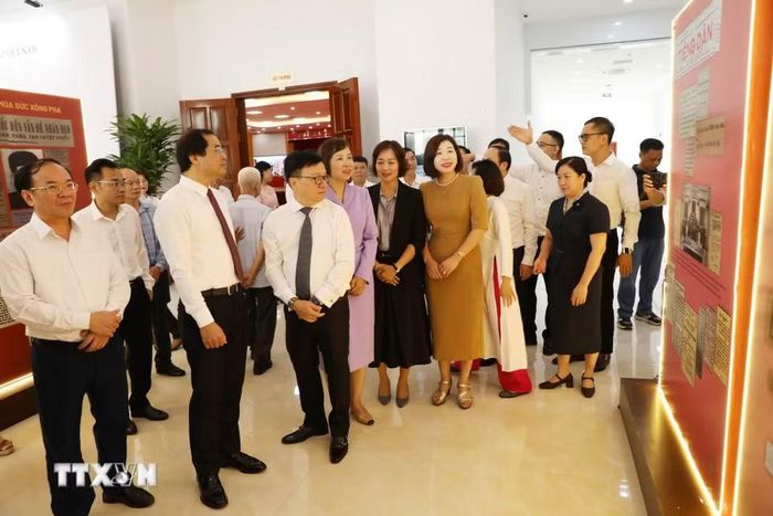 Đại biểu tìm hiểu thông tin về nhà chiến sỹ yêu nước Huỳnh Thúc Kháng tại khu trưng bày sự kiện. (Ảnh: Vũ Hoàng Giang/TTXVN)