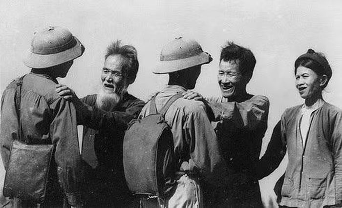 Cụ Nguyễn Danh Mai (trái) và cụ Hoàng Phi Sơn, ở xã Diễn Minh, huyện Diễn Châu (Nghệ An), đều có 3 con tòng quân, nay lại tiễn người con thứ 4 lên đường nhập ngũ kháng chiến chống Mỹ, cứu nước, tháng 8/1964, sau khi Mỹ mở rộng đánh phá bằng không quân ra miền Bắc. (Ảnh: Nguyễn Chính/TTXVN)