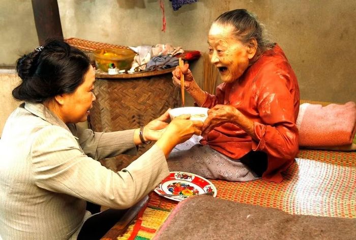 Cộng tác viên dân số hỗ trợ chăm sóc người cao tuổi có hoàn cảnh đặc biệt khó khăn tại huyện Hòa Vang, Đà Nẵng (2018). (Ảnh: Dương Ngọc/TTXVN)