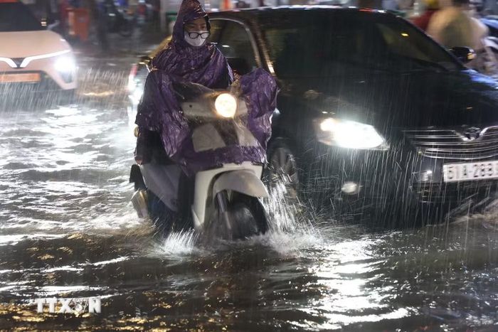 Người dân Thành phố Hồ Chí Minh di chuyển trong mưa và ngập tối 30/9. (Ảnh: Hồng Đạt/TTXVN)