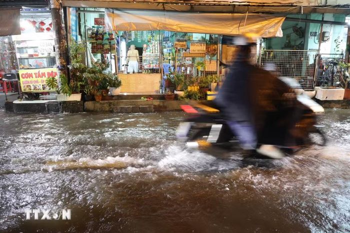 Nước dâng do mưa và triều cường, nguy cơ nước tràn vào nhà dân tối 30/9 trên đường Bình Quới, phường Bình Quới. (Ảnh: Hồng Đạt/TTXVN)