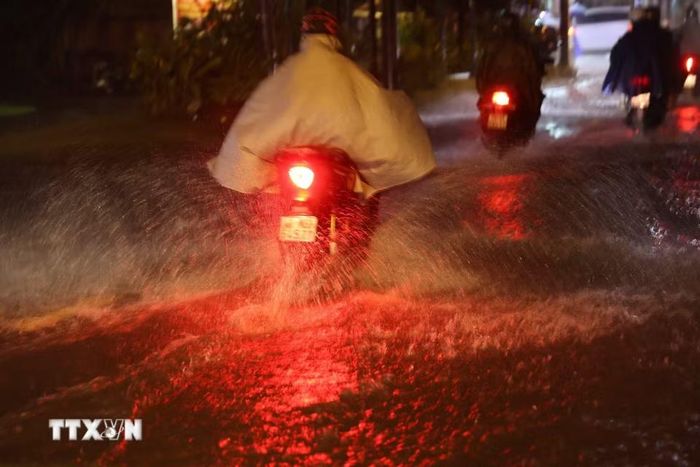 Người dân Thành phố Hồ Chí Minh di chuyển trong mưa và ngập tối 30/9 trên đường Bình Quới, phường Bình Quới. (Ảnh: Hồng Đạt/TTXVN)