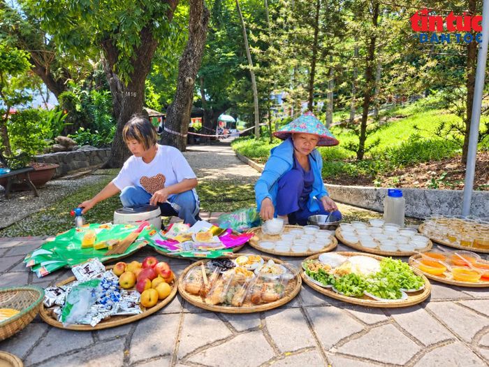 Bà Đỗ Thị Thanh Hường (bên phải) cùng bà Kim Cúc chuẩn bị mâm lễ cho các anh hùng liệt sĩ tại công viên Lê Thị Riêng.
