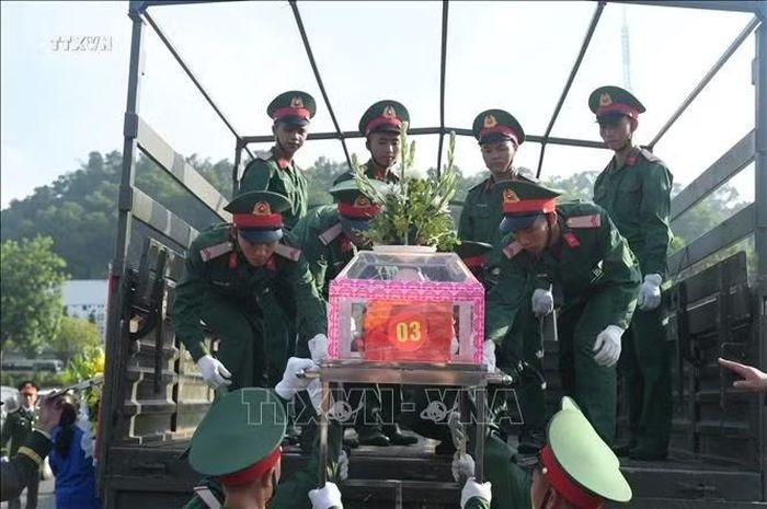Di quan hài cốt liệt sĩ về nghĩa trang an táng. Ảnh: Hương Thu/TTXVN
