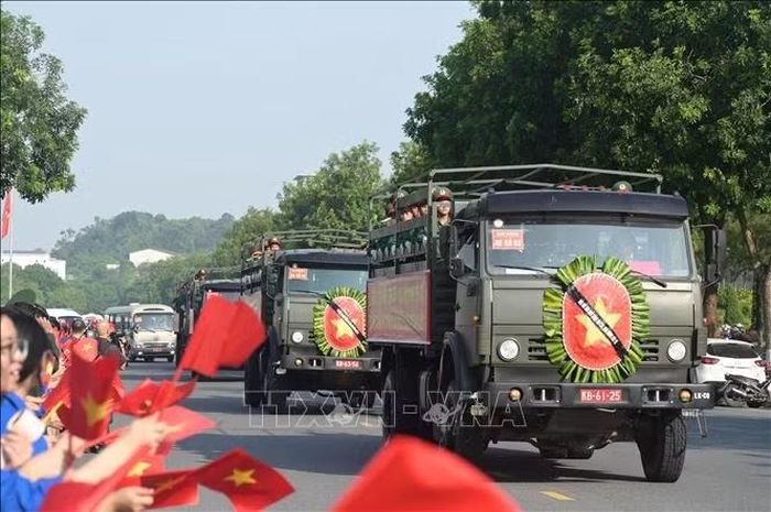 Thực hiện nghi lễ di quan hài cốt liệt sĩ ra nghĩa trang an táng. Ảnh: Hương Thu/TTXVN