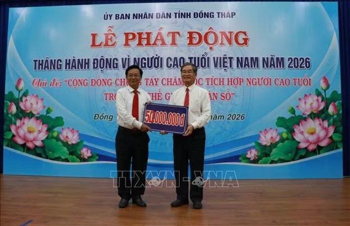 Đại diện Hội Người cao tuổi tỉnh nhận bảng tượng trưng hỗ trợ kinh phí chăm lo cho người cao tuổi.