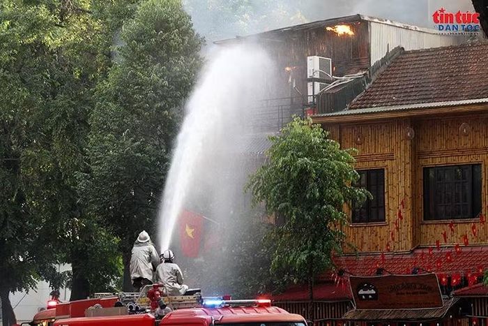Dòng nước áp lực lớn được phun trực tiếp vào khu vực tầng trên, nơi lửa và khói vẫn bốc lên.