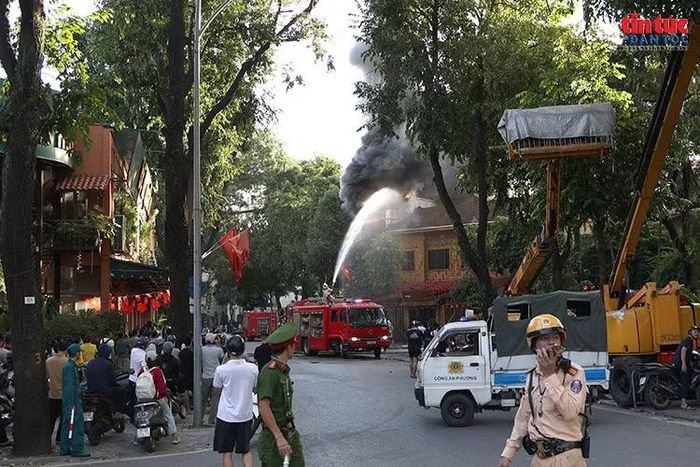 Lực lượng Cảnh sát PCCC và CNCH triển khai phương tiện, phun nước khống chế đám cháy tại quán ăn trên phố Tăng Bạt Hổ.