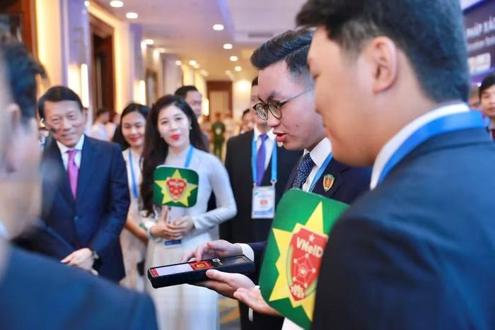 Các đại biểu trải nghiệm ứng dụng xác minh di động. Ảnh; C06.