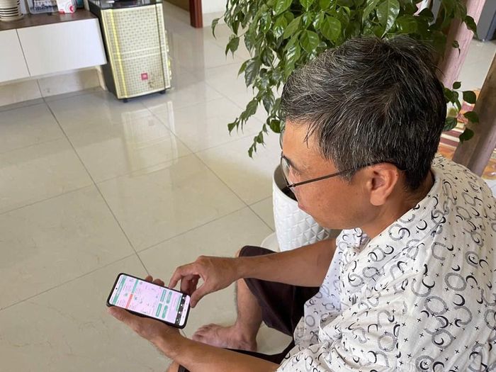 Anh Phạm Văn Hoàng Thuỷ kiểm tra mức độ tiêu thụ điện của thiết bị qua điện thoại. Ảnh: Anh Nguyễn/Bnews/vnanet.vn