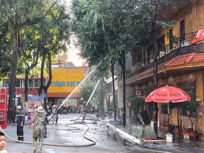 Lực lượng chức năng đang khẩn trương xử lý đám cháy, ngăn chặn ngọn lửa lây lan. Ảnh: Lê Đông - TTXVN