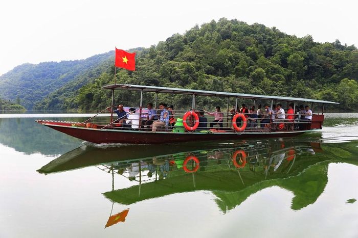 Du khách đi thuyền du lịch tại Hồ Cấm Sơn. Ảnh: Danh Lam - TTXVN