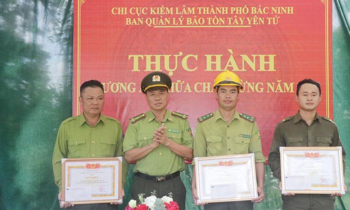  Đồng chí Nguyễn Văn Hiệu, Phó Chi cục trưởng Chi cục Kiểm lâm thành phố Bắc Ninh tặng Giấy khen cho các tập thể, cá nhân có thành tích trong thực hành chữa cháy rừng. 