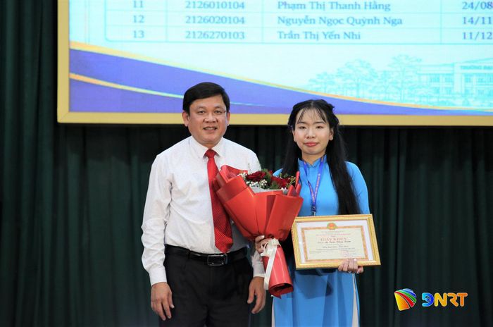 PGS.TS. Huỳnh Trọng Dương, Hiệu trưởng Trường Đại học Quảng Nam trao giấy khen cho sinh viên Lê Trần Thùy Trâm, thủ khoa trong kỳ thi tuyển sinh đại học hệ chính quy năm 2026. Ảnh: ĐĂNG NGUYÊN
