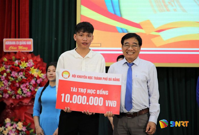 Đại diện Hội Khuyến học thành phố Đà Nẵng tài trợ học bổng 10 triệu đồng cho sinh viên Trường Đại học Quảng Nam. Ảnh: ĐĂNG NGUYÊN