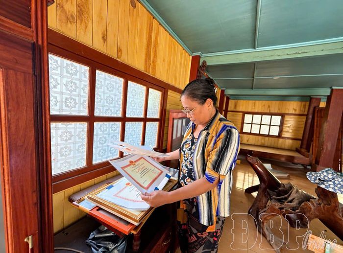 Bà Lương Thị Đợi cẩn thận thu xếp bằng khen, giấy khen và những kỷ vật trước khi chuyển đến nơi ở mới.