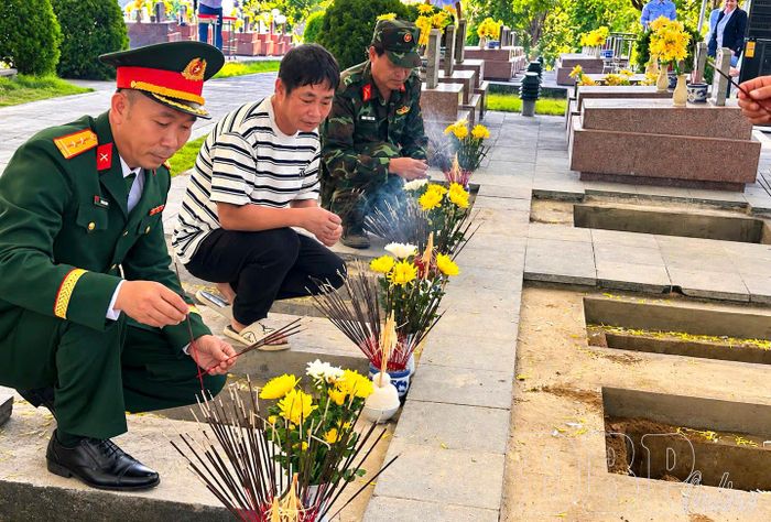 Ông Hoàng Thanh Hưng (ở giữa) thắp hương tại các phần mộ liệt sĩ trước khi hoàn tất công tác quy tập về Nghĩa Trang Liệt sĩ Tông Khao.