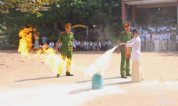 Học sinh thực hành sử dụng bình chữa cháy.