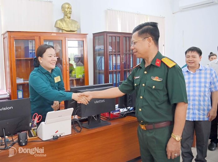 Đại tá Nguyễn Thanh Phong động viên nữ dân quân đang làm việc tại Ban Chỉ huy quân sự xã Xuân Hòa. Ảnh: Văn Chung
