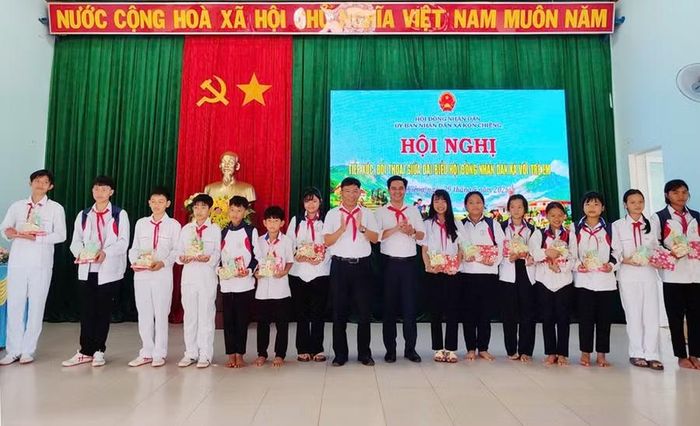 Thường trực HĐND xã trao quà cho các em học sinh tham dự buổi đối thoại. Ảnh: P.N 