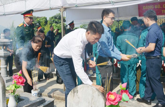 Các đồng chí lãnh đạo Quân khu 2, tỉnh Lào Cai và cán bộ, người dân địa phương rải hoa, rải cát và thắp hương tiễn biệt liệt sĩ.
