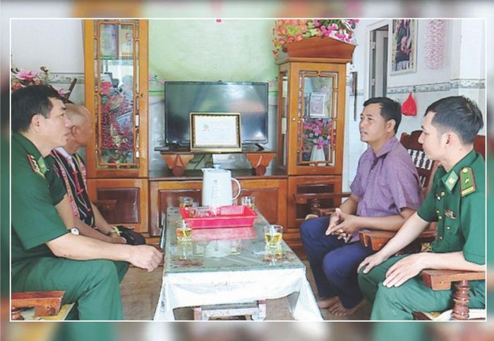 Cán bộ Đồn Biên phòng Cửa khẩu Thuận An trao đổi công việc với già làng, người uy tín