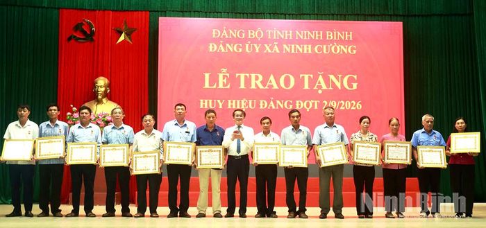 Lãnh đạo xã Ninh Cường trao tặng Huy hiệu Đảng cho các đảng viên. Ảnh: Hồng Ngọc