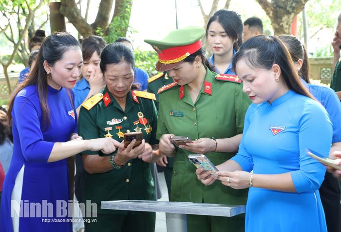 Đoàn viên, thanh niên phường Hà Nam hướng dẫn cán bộ, nhân dân quét mã QR để tìm hiểu thông tin số hóa về di tích Lam Hạ.