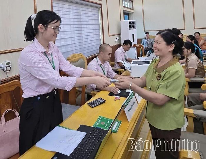 Cán bộ tín dụng phòng giao dịch NHCSXH Tân Sơn giải ngân vốn vay ưu đãi cho khách hàng.