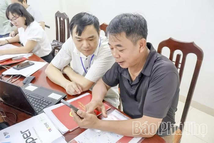 Anh Phan Văn Thuấn, thôn Môn Dài, xã Thung Nai được cán bộ hướng dẫn thủ tục gia hạn quyền sử dụng đất trên môi trường số.