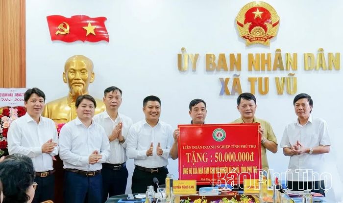 Đại diện Liên đoàn Doanh nghiệp tỉnh trao biểu trưng kinh phí hỗ trợ xóa nhà tạm cho hộ nghèo xã Tu Vũ.
