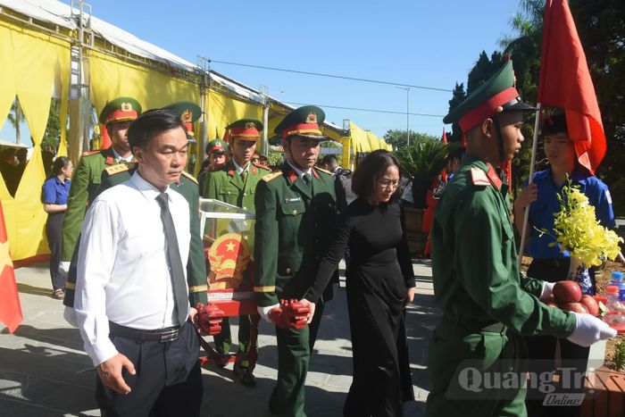 Các đồng chí lãnh đạo tỉnh thực hiện nghi thức di chuyển hài cốt liệt sĩ đến nơi an táng - Ảnh: Đ.V