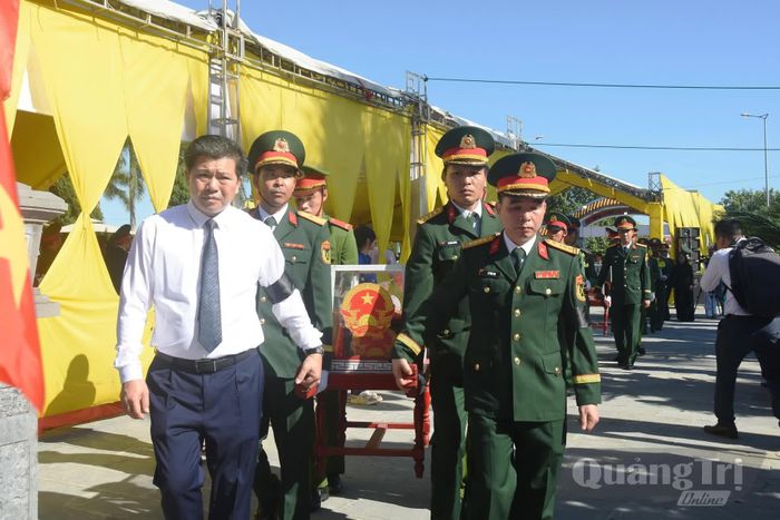 Các đồng chí lãnh đạo tỉnh thực hiện nghi thức di chuyển hài cốt liệt sĩ đến nơi an táng - Ảnh: Đ.V