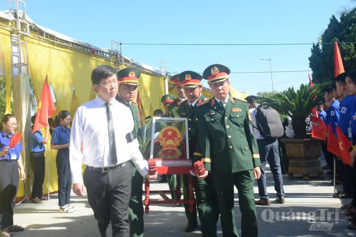 Các đồng chí lãnh đạo tỉnh thực hiện nghi thức di chuyển hài cốt liệt sĩ đến nơi an táng - Ảnh: Đ.V