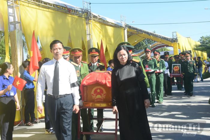 Đồng chí Nguyễn Thị Tuyến, Phó Bí thư Đảng ủy Chính phủ và đồng chí Vương Quốc Tuấn, Bí thư Tỉnh ủy Quảng Trị thực hiện nghi thức di chuyển hài cốt liệt sĩ đến nơi an táng - Ảnh: Đ.V