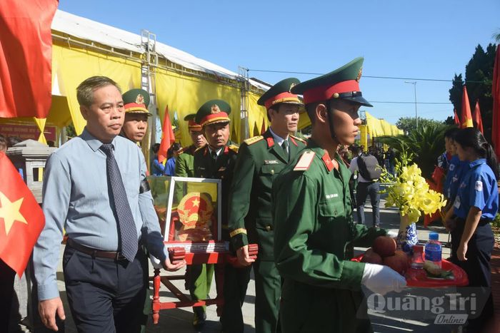 Các đồng chí lãnh đạo tỉnh thực hiện nghi thức di chuyển hài cốt liệt sĩ đến nơi an táng - Ảnh: Đ.V