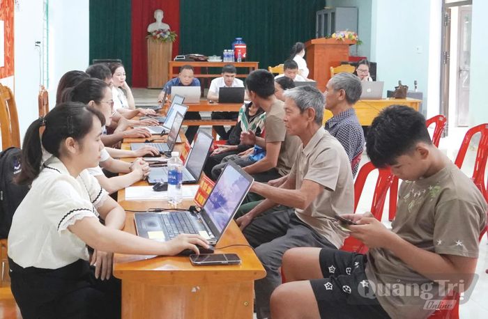 Đông đảo người dân thôn Tiến Hóa, xã Minh Hóa, đến nhà văn hóa thôn giải quyết thủ tục hành chính - Ảnh: X.V