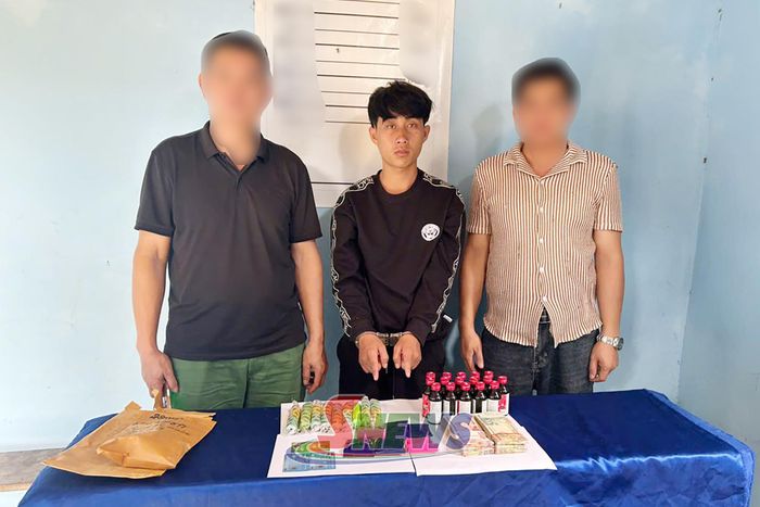Đối tượng Thạo Nong Lăm (ở giữa) cùng tang vật tại cơ quan Công an