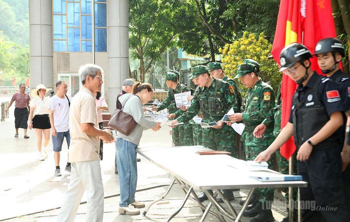 Các lực lượng phát tờ rơi tuyên truyền pháp luật cho cư dân qua lại cửa khẩu.