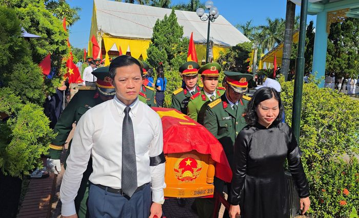 Bà Nguyễn Thị Tuyến, Phó bí thư Đảng ủy Chính phủ (bên phải) và ông Vương Quốc Tuấn, Bí thư Tỉnh ủy Quảng Trị (bên trái) thực hiện nghi thức di chuyển hài cốt liệt sĩ đến nơi an táng.