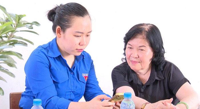 Đoàn viên phường Mỹ Phong hướng dẫn người dân sử dụng VNeID. (Ảnh: P.Thanh)