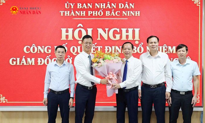 Phó Chủ tịch HĐND thành phố Nghiêm Xuân Hưởng tặng hoa chúc mừng tân Giám đốc Sở Khoa học và Công nghệ Thân Trung Kiên. Ảnh: Huyền Thương