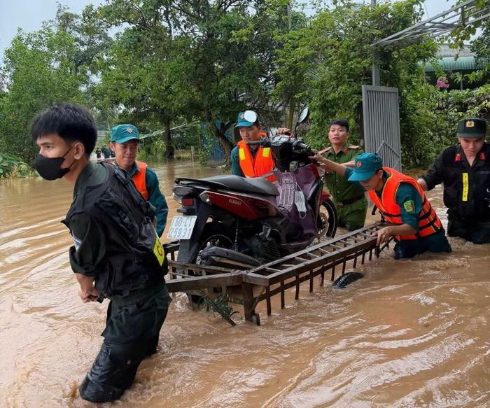 Công an phường Long Thành và Dân quân tự vệ phường di chuyển tài sản của người dân bị ngập ra khỏi nhà đến nơi cao ráo.
