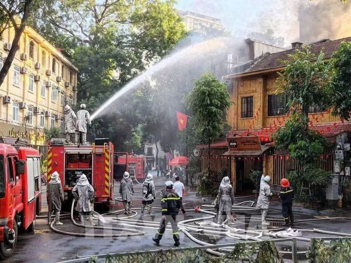 Cảnh sát PCCC sử dụng vòi rồng phun nước từ dưới mặt đường lên tầng 3.