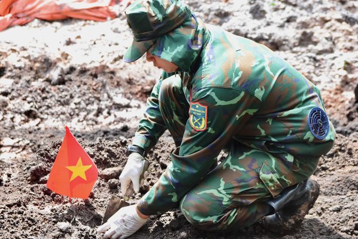 Các cán bộ chiến sĩ cẩn trọng đào bới, tìm kiếm từng mẩu hài cốt liệt sĩ tại Công viên Lê Thị Riêng.