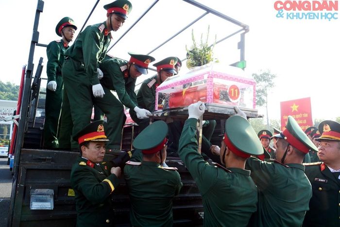 Đưa hài cốt các liệt sĩ lên xe quân đội. Ảnh: Quốc Hồng